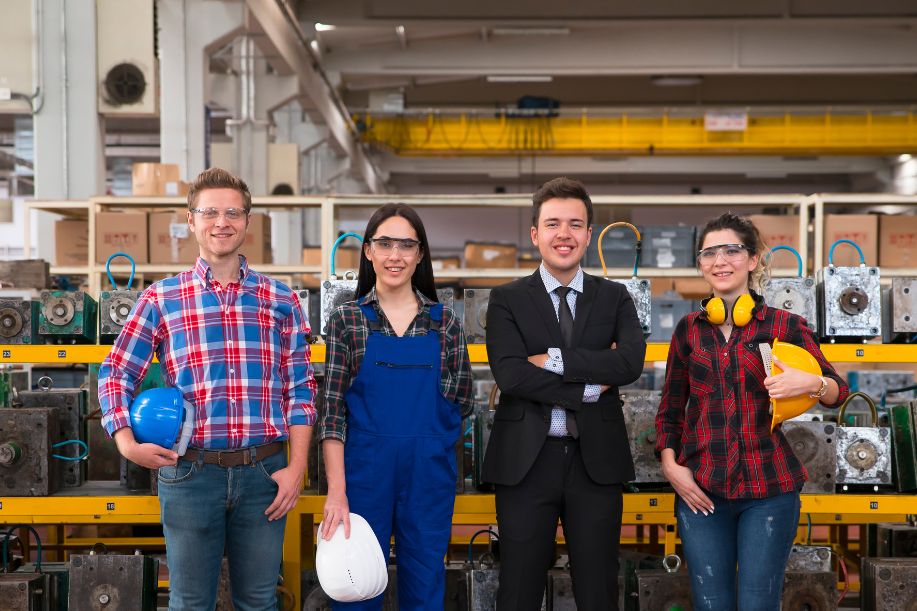 4 Trabajadores en una fábrica, posando para una foto de frente
